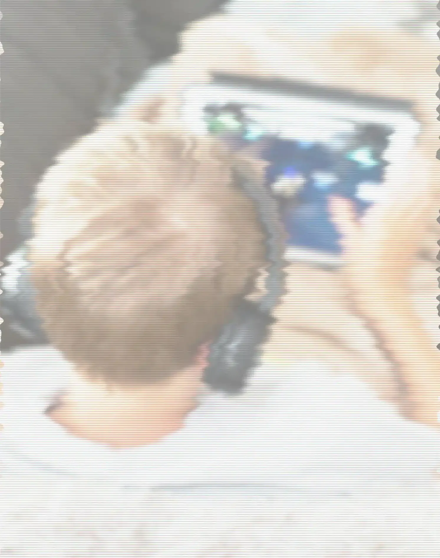 A person lying in bed wearing headphones, holding a tablet and watching a video. The image has a hazy, distorted filter with horizontal lines, creating a nostalgic, screen-like or dreamlike effect that evokes digital immersion or distraction.